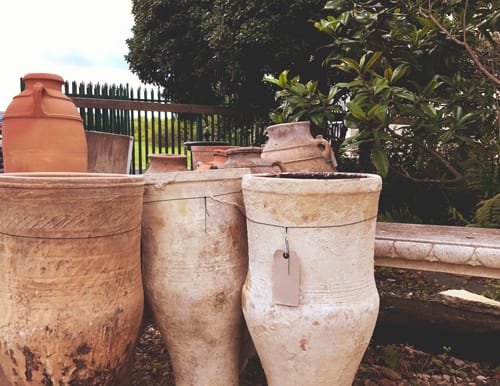 A range of terracotta amphorae arranged by a vicenza stone bench